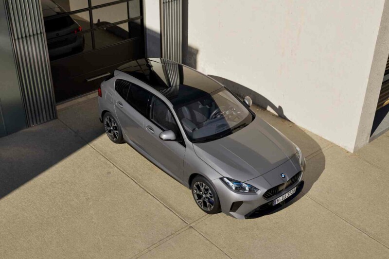 Ein BMW 1er in skyscraper grau parkt an einem Bürogebäude.